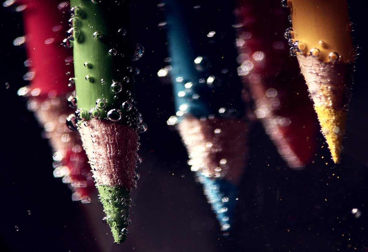 Vibrant colored pencils submerged in water